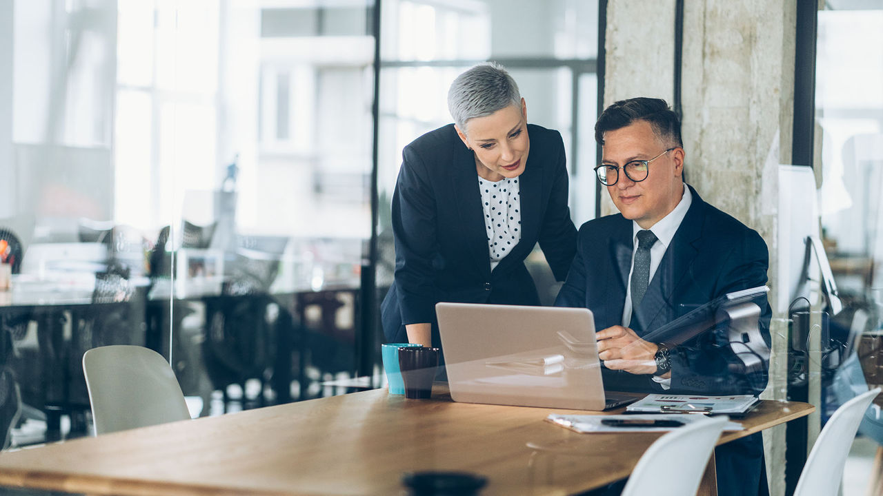 Two business professionals looking at a laptop