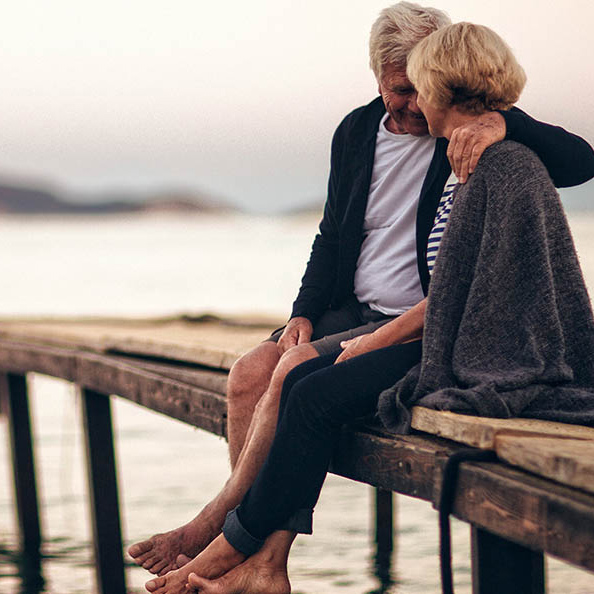 older couple cuddling at the beach