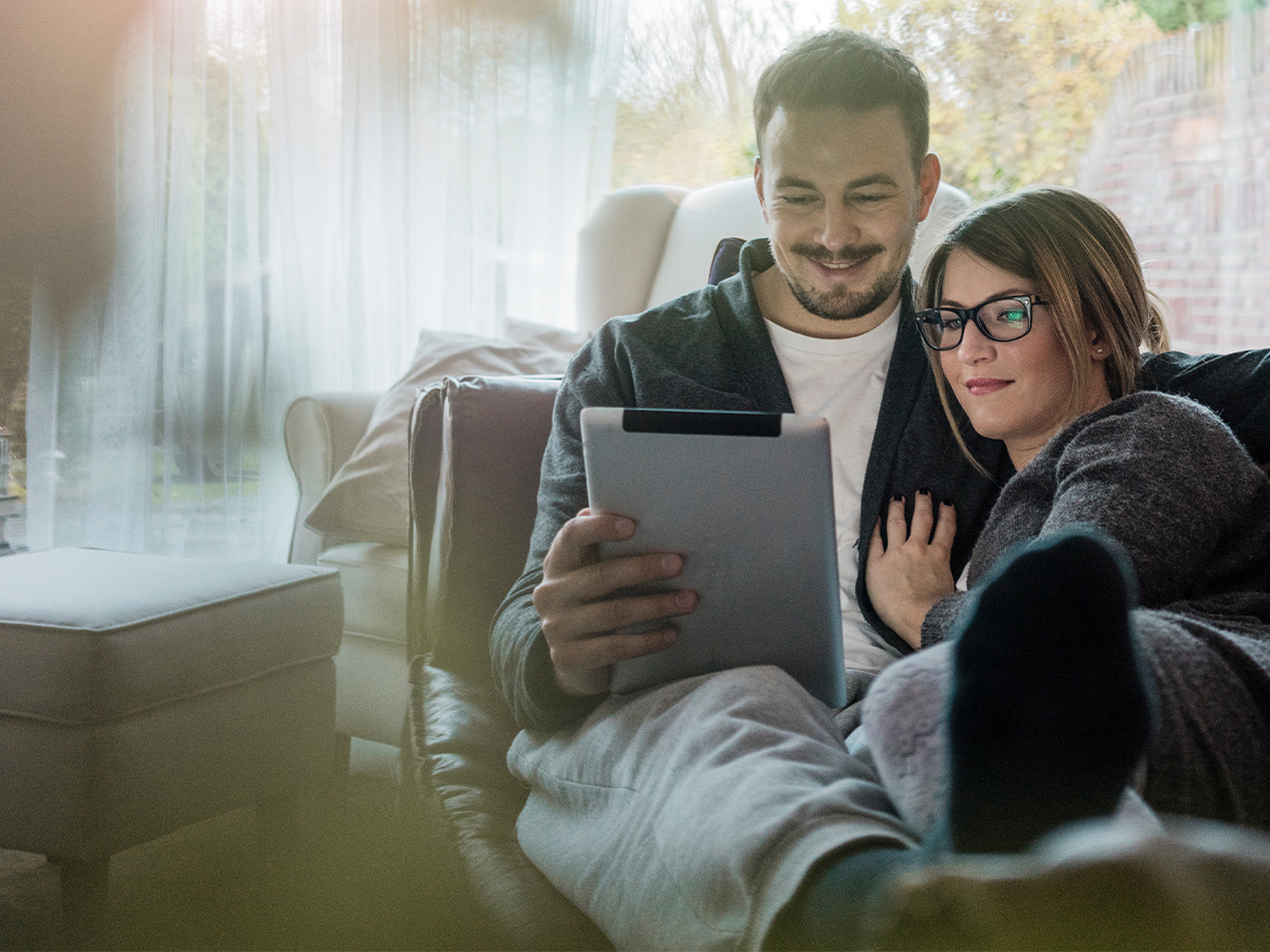 Couple on sofa looking at tablet