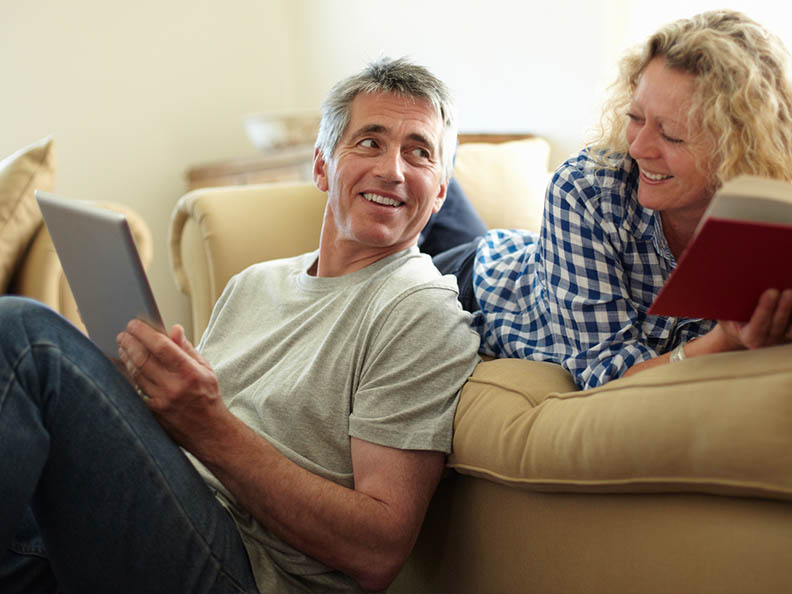 middle-aged couple on lounge smiling at each other